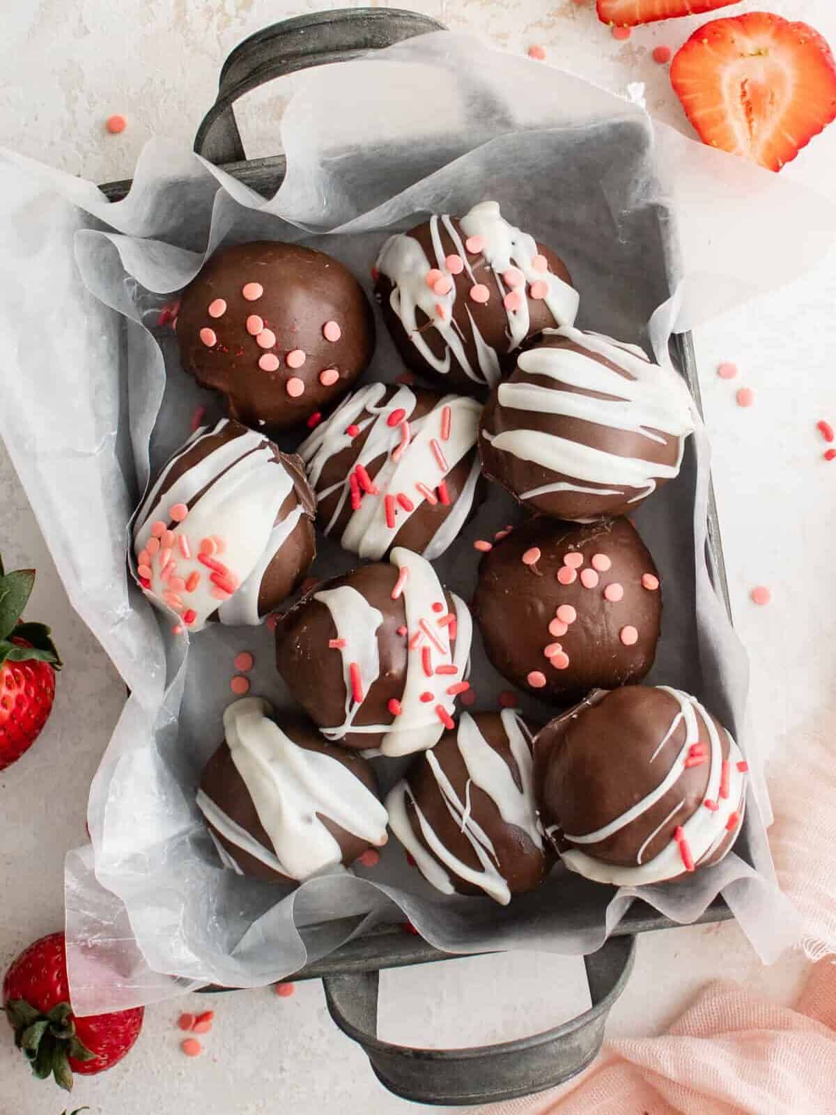 overhead view of strawberry truffles in a small parchment lined basket.