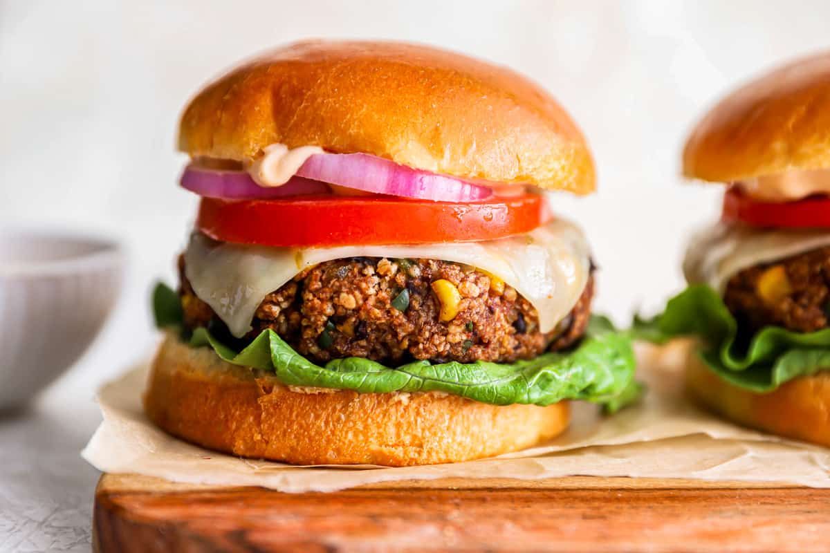 two homemade veggie burgers on a wooden cutting board.