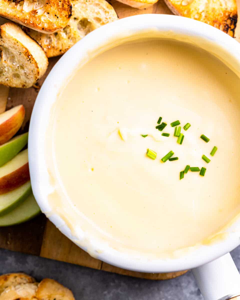 overhead view of cheese fondue in a white pot.