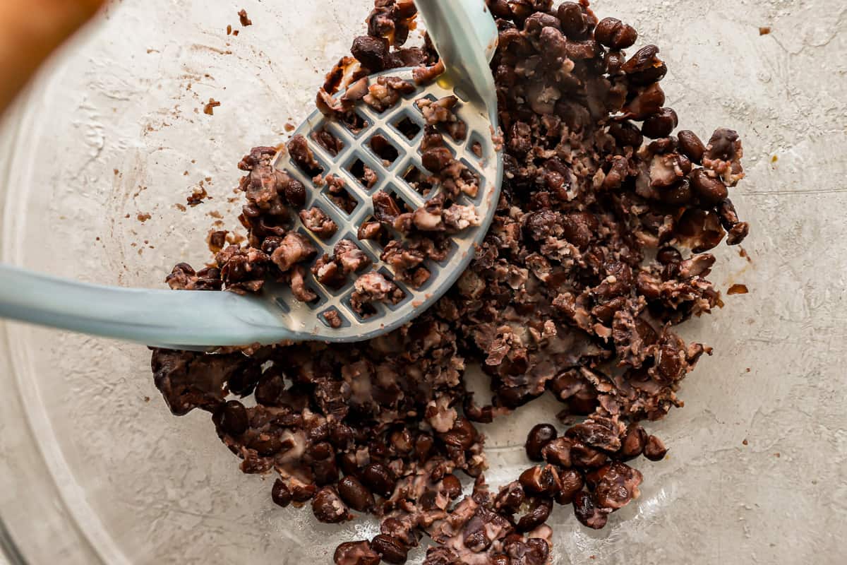 a person scooping chocolate chips into a bowl.