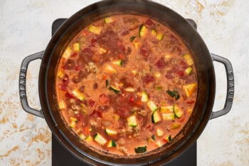 sausage lentil soup simmering in a dutch oven.