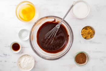 melted chocolate and butter in a glass bowl with a whisk.