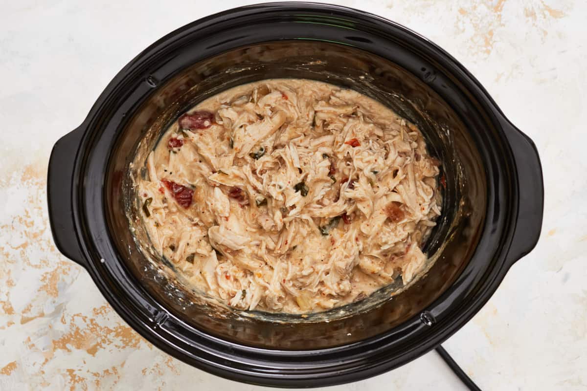 shredded crockpot alfredo chicken in a crockpot.