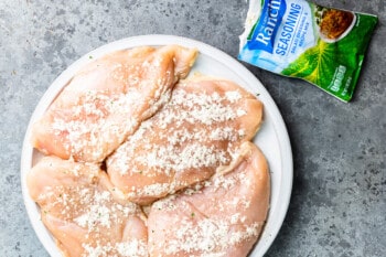 ranch seasoned raw chicken breasts on a white plate.