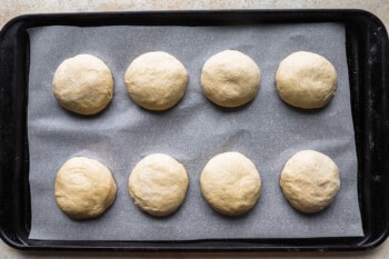 six dough balls on a baking sheet.