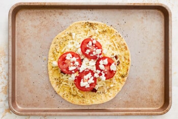 black pepper cracked over unbaked white pizza.