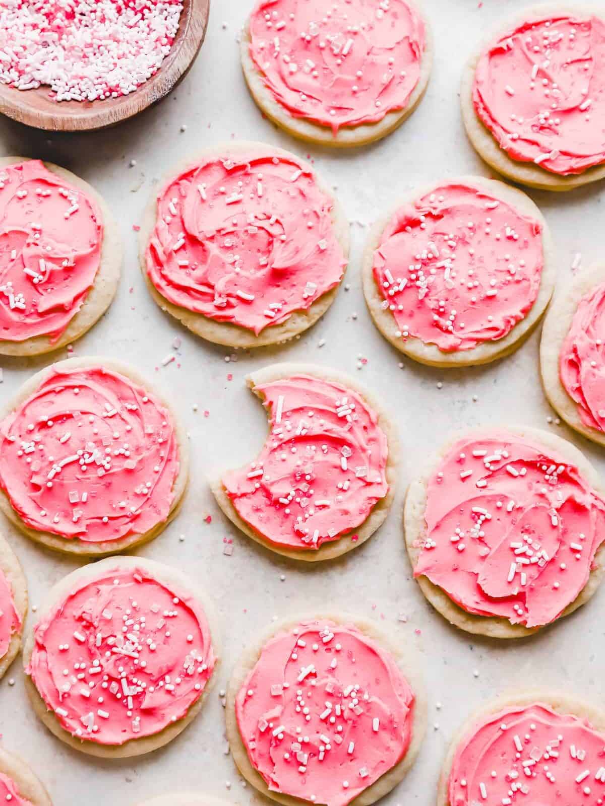 overhead view of lofthouse cookies on parchment, one is bitten.