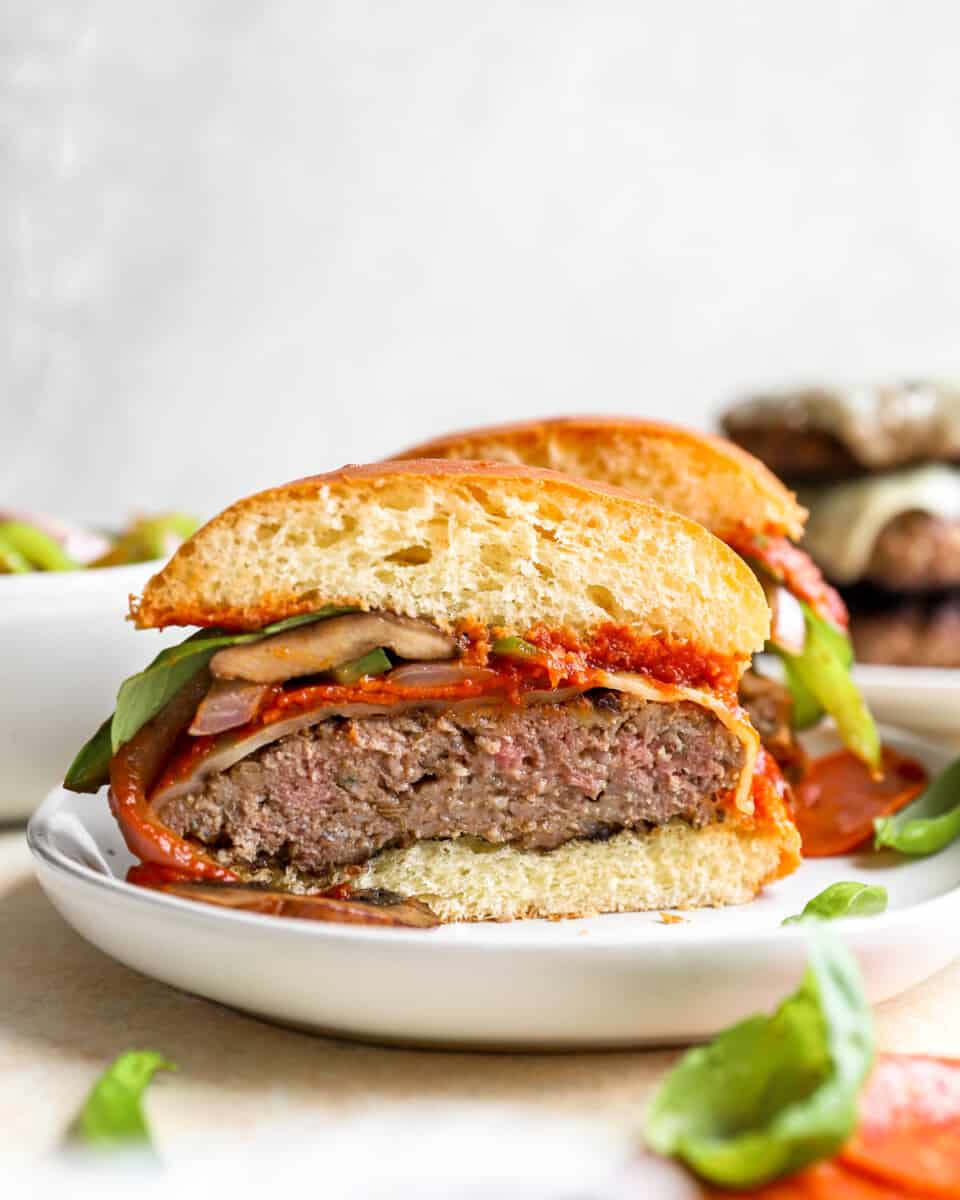 a burger with pepperoni and cheese on a plate.