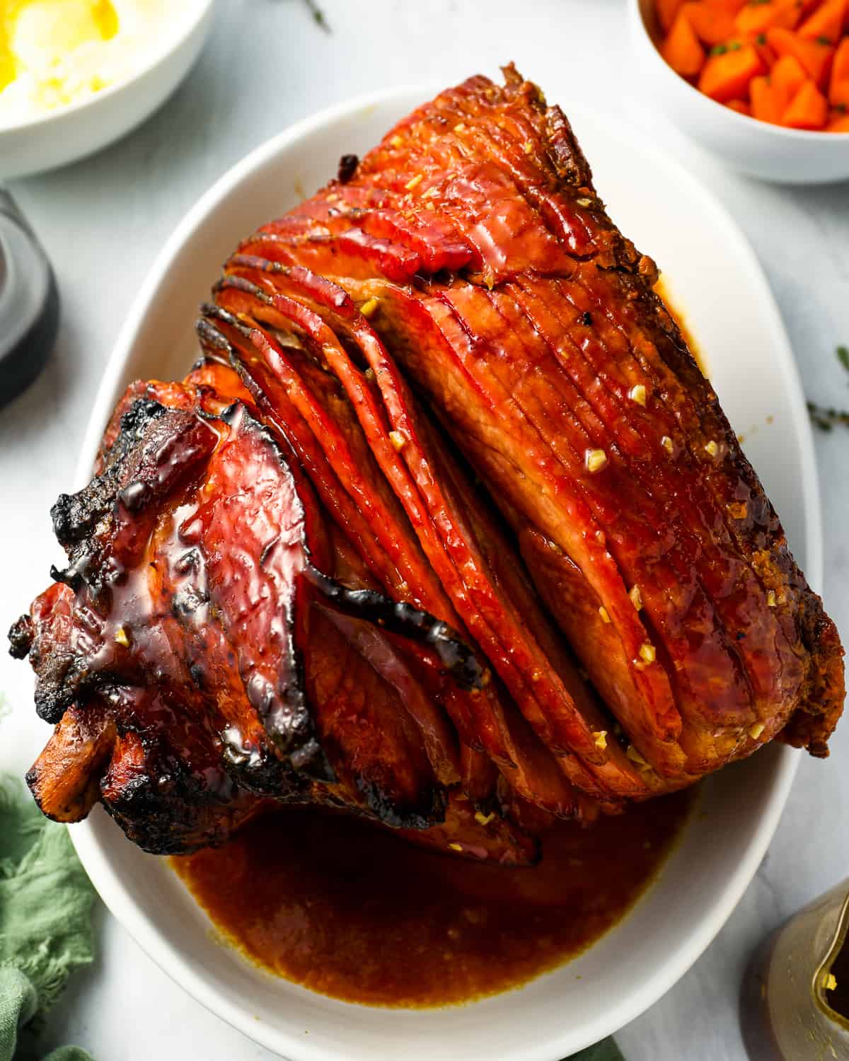 overhead view of smoked ham on a white plate.