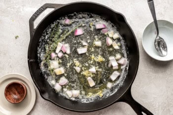 sauteeing shallots in melted butter in a cast iron pan.