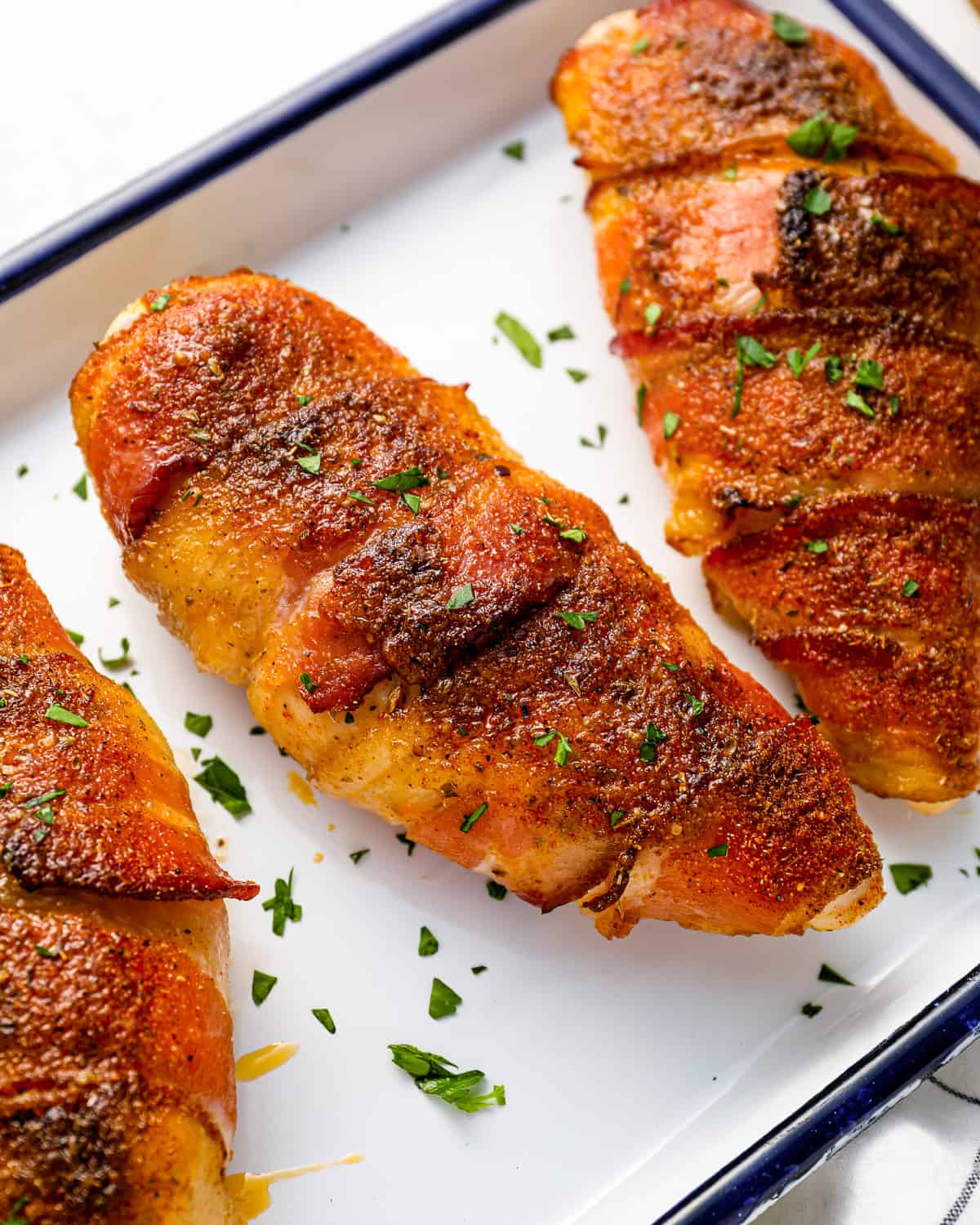 bacon wrapped chicken breasts on a baking sheet.