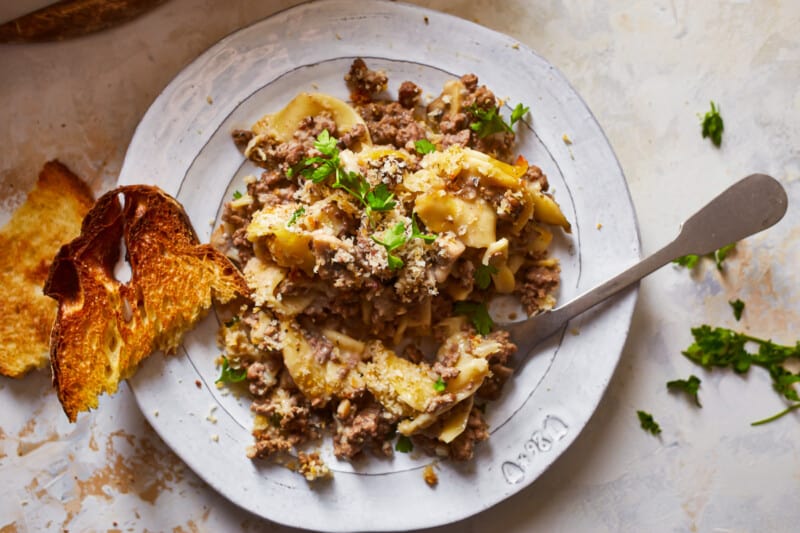 a plate of pasta with meat and bread on it.