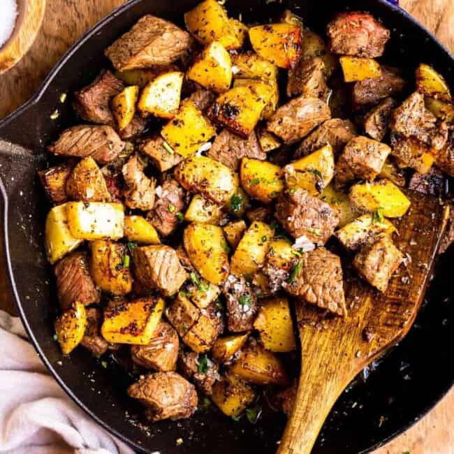 garlic butter steak bites with potatoes in skillet