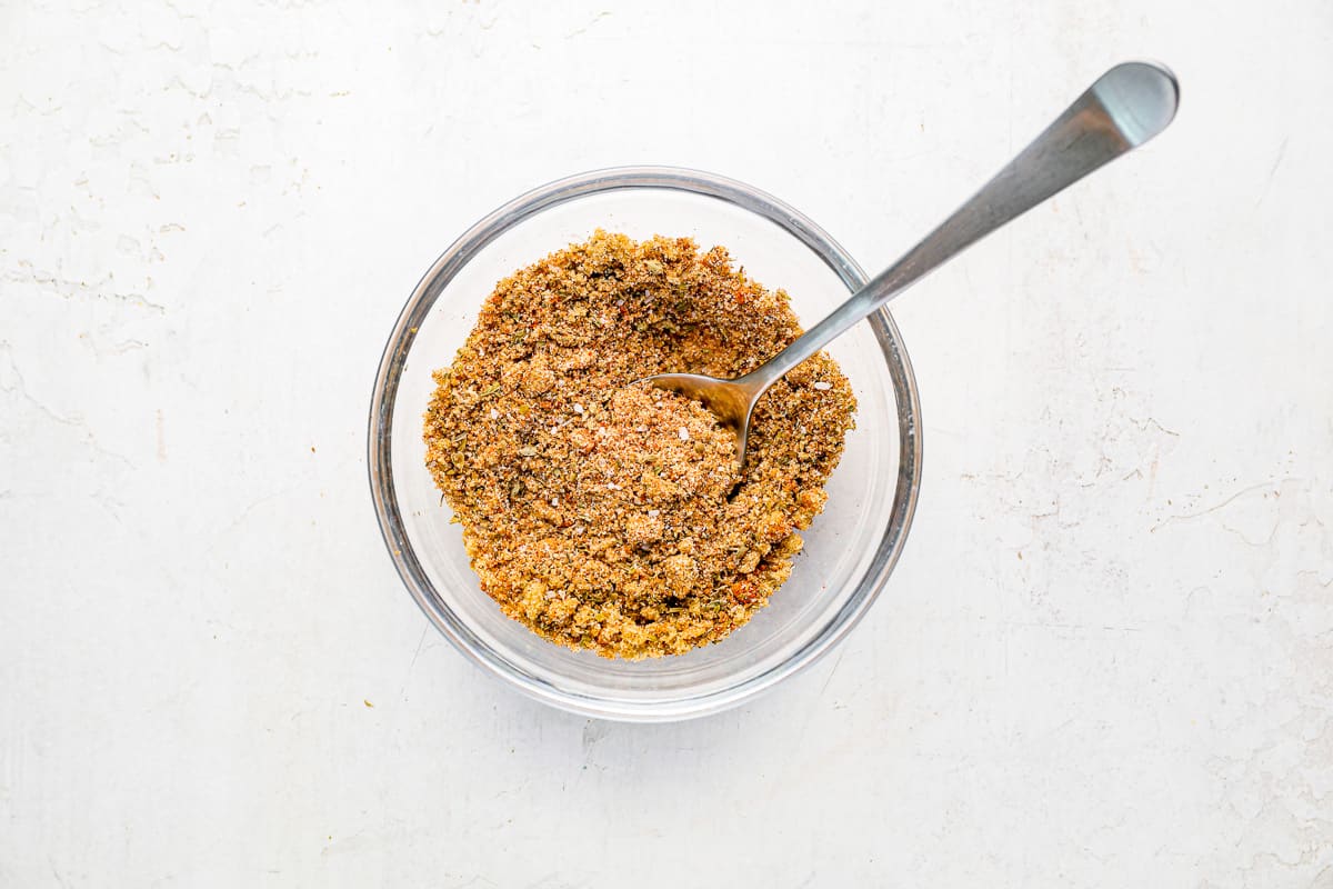 seasonings in a glass bowl with a spoon.