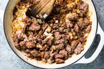 a skillet filled with meat and onions.