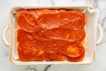 a baking dish filled with a tomato sauce.