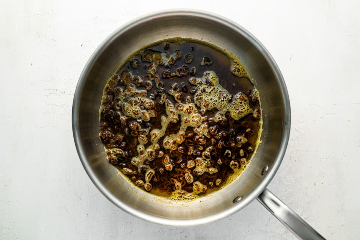 a frying pan filled with oil and spices.