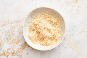 a bowl of rice on a white surface.