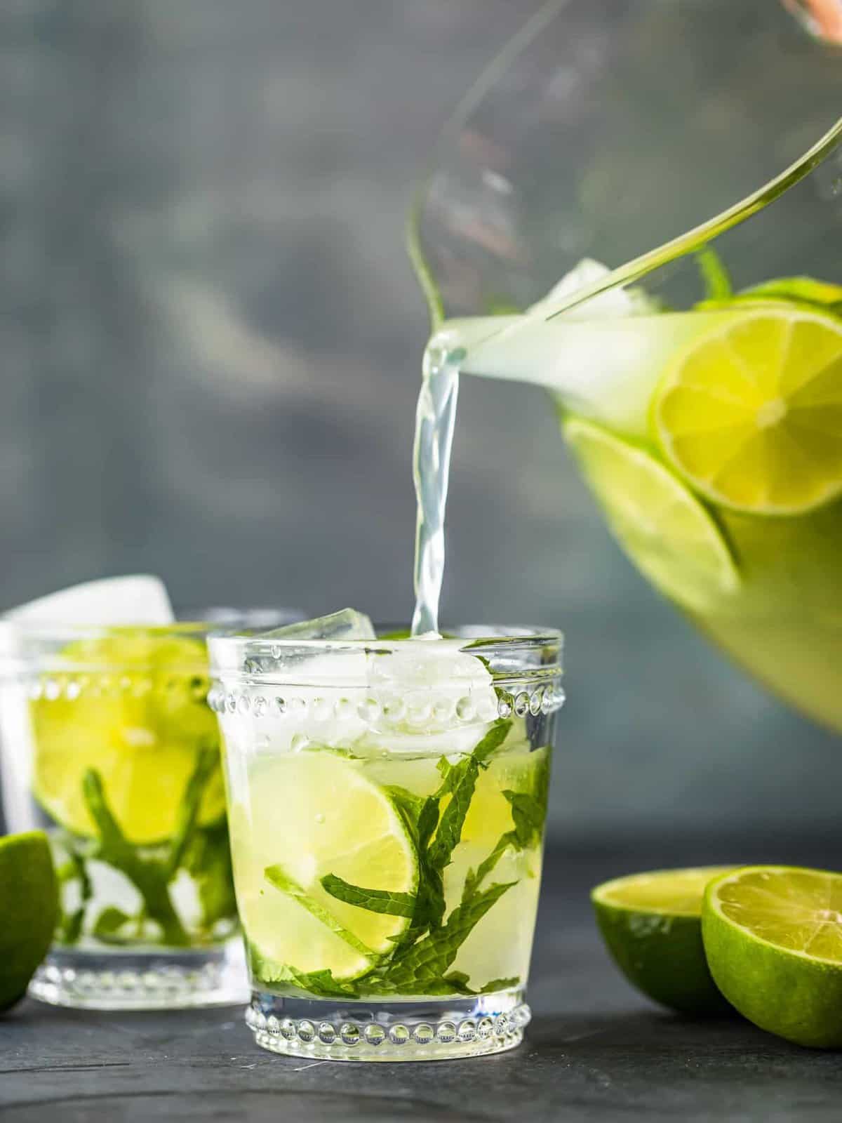 pouring mojitos into glasses