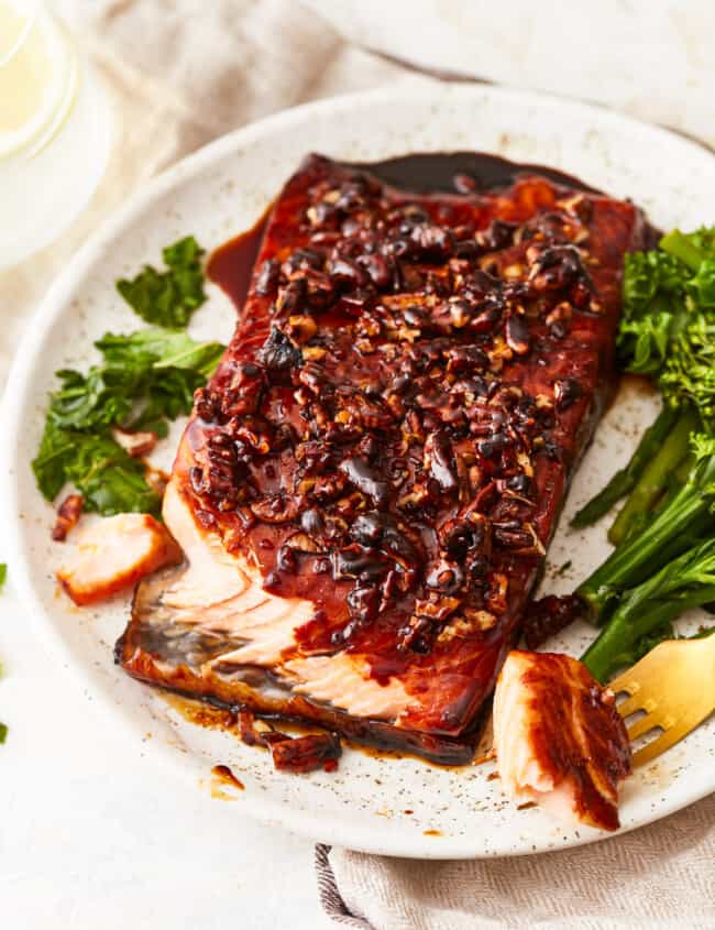 A plate with salmon and greens on it.