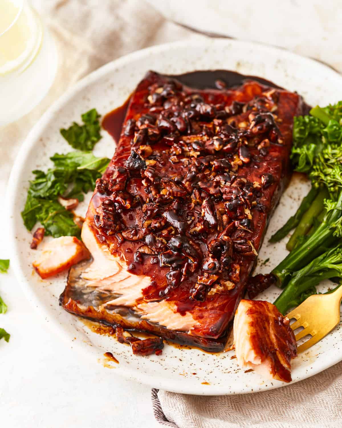 a bourbon brown sugar glazed salmon filet on a plate with broccolini.