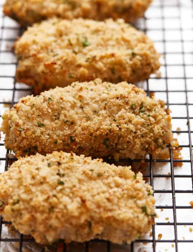 Fried chicken breasts on a cooling rack.