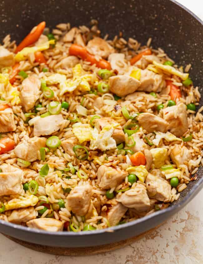 A frying pan filled with chicken and vegetables.