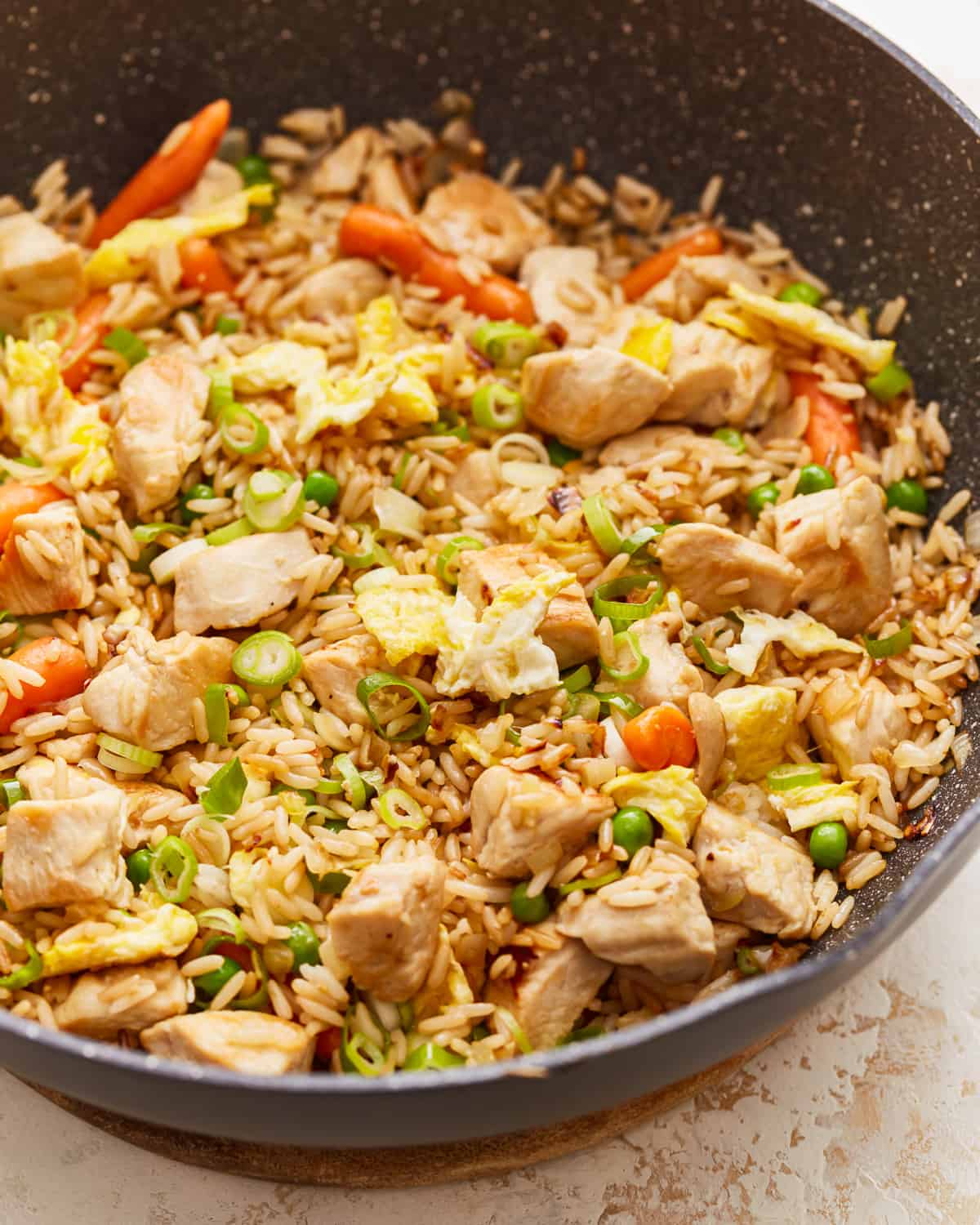 A frying pan filled with chicken and vegetables.