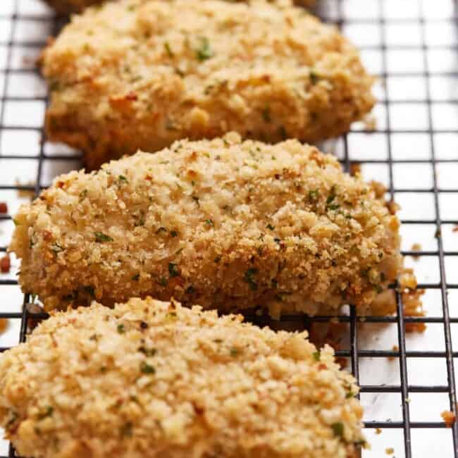 Fried chicken breasts on a cooling rack.