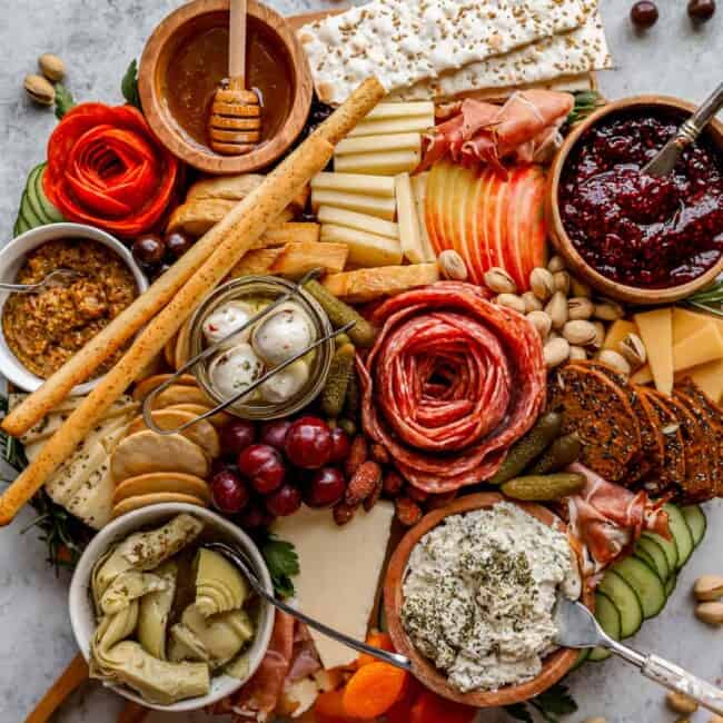 A platter of cheese, fruit, nuts and crackers.