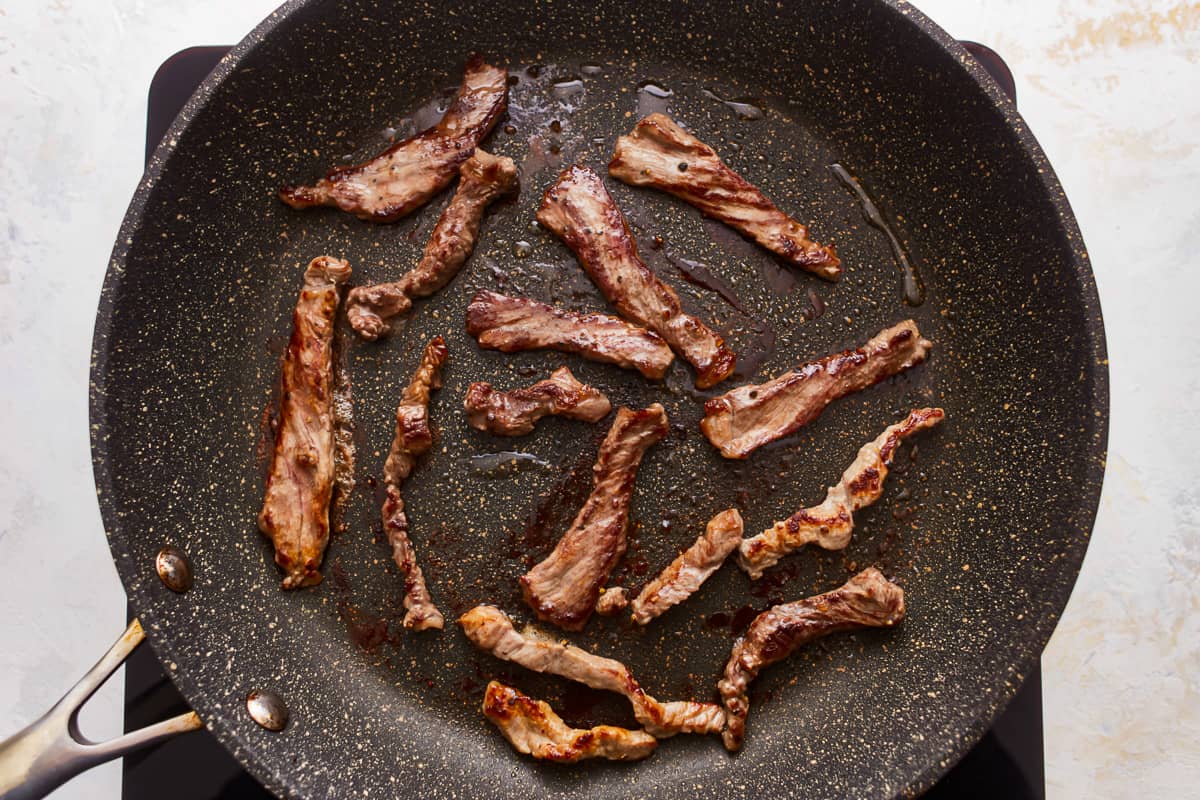 A frying pan with meat in it.