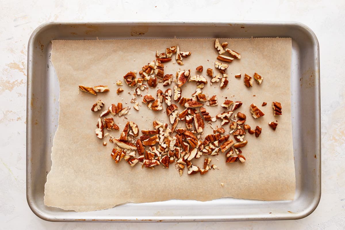 Chopped pecans on a baking sheet.