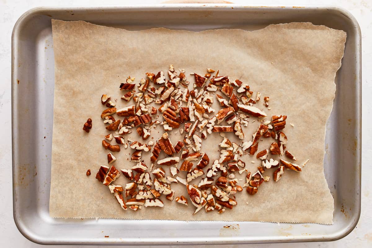 Toasted chopped pecans on a baking sheet.