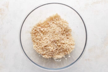 Granola in a glass bowl on a white background.