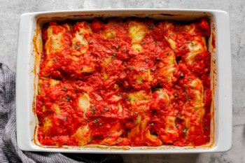 Stuffed cabbage rolls in a white baking dish.