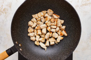 Fried chicken in a wok on a white background.