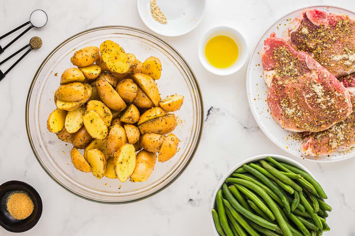 A bowl of halved baby potatoes coated in a seasoning mix.