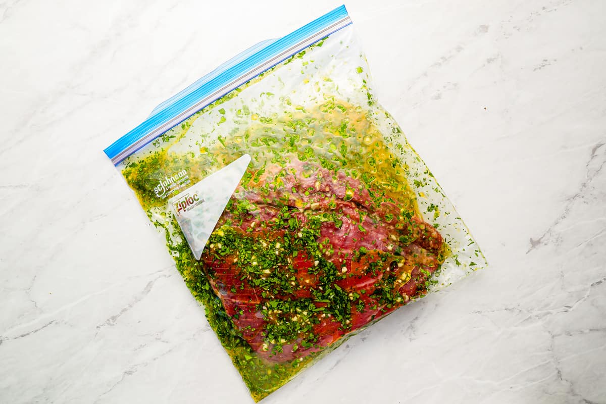 Flank steak in a resealable bag with an herb-filled marinade.