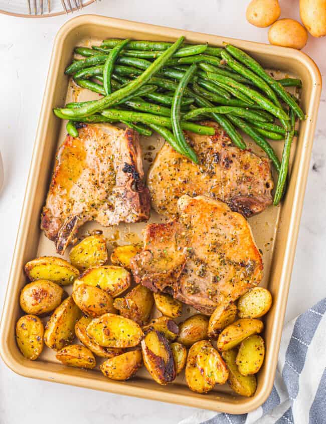 A baking sheet with potatoes and green beans.