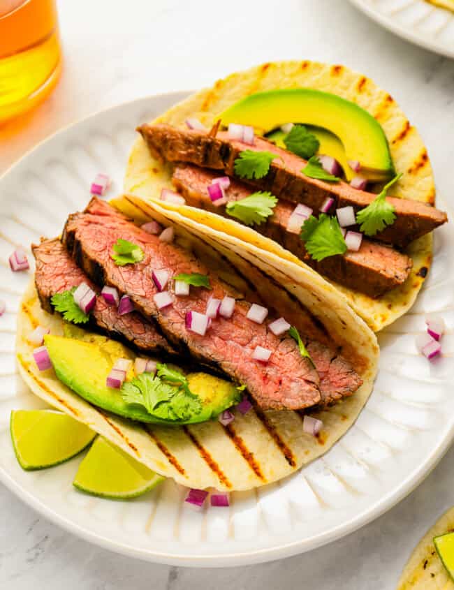 Grilled steak tacos with avocado and lime.