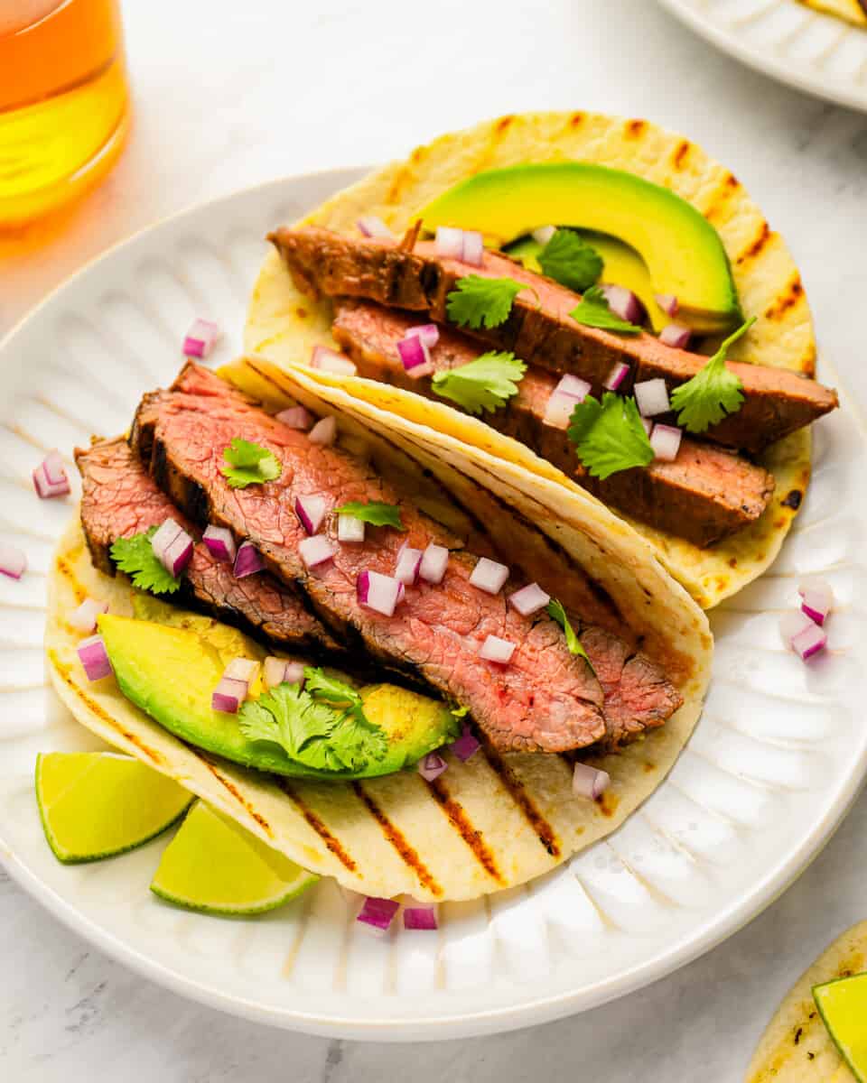 Grilled steak tacos with avocado and lime.