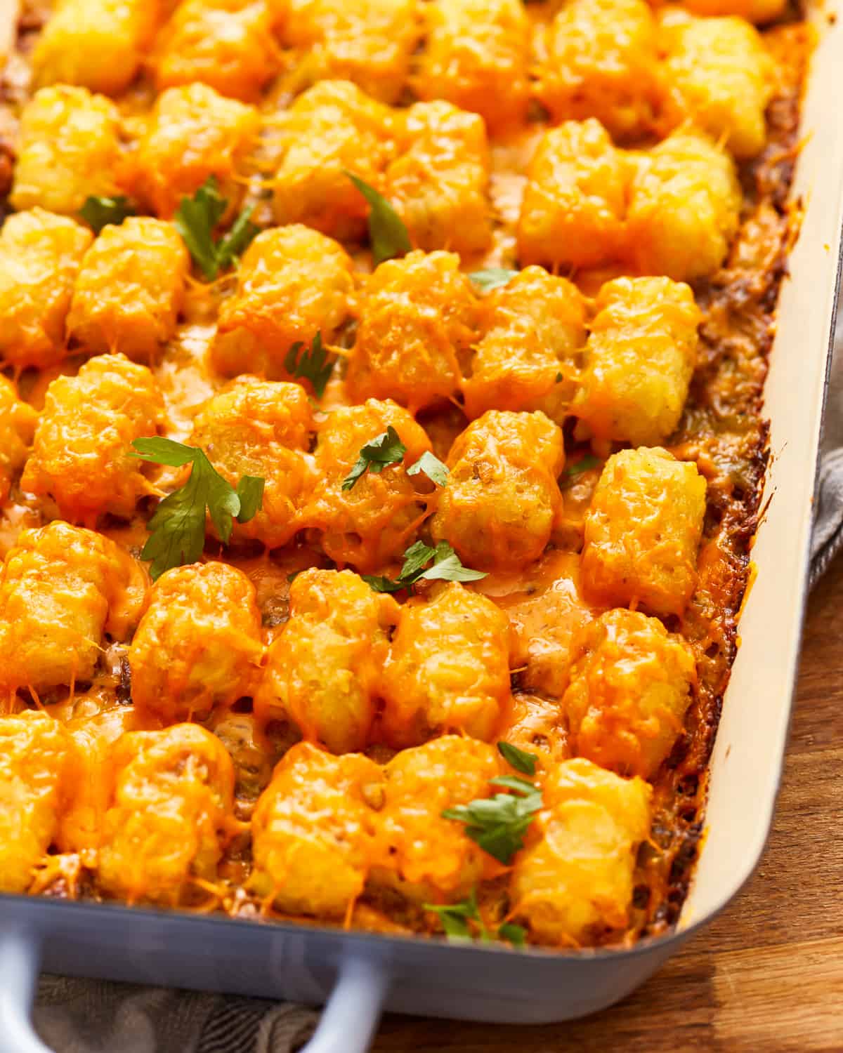 Cheesy tater tot casserole in a blue dish.