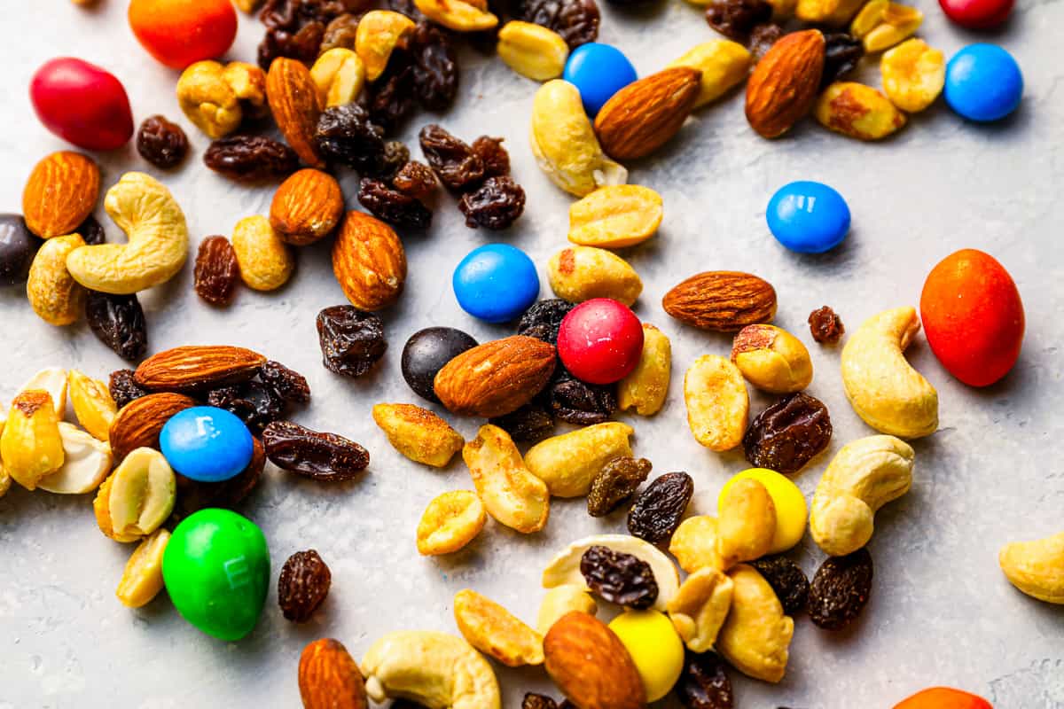 A pile of mixed nuts and raisins on a white surface.