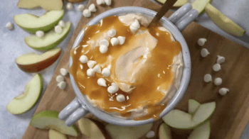 overhead view of cream cheese caramel apple dip topped with caramel sauce and white chocolate chips.