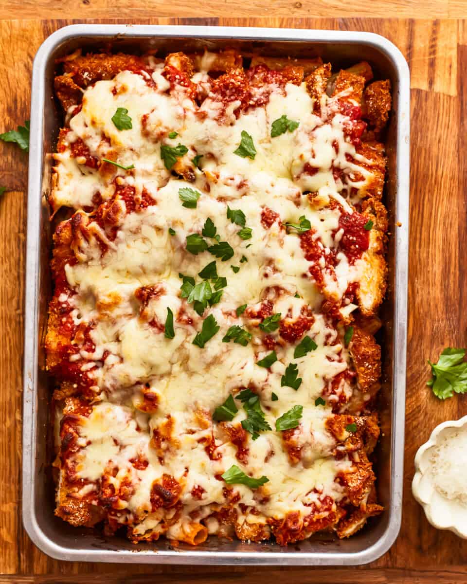 Lasagna in a baking dish with cheese and parmesan.