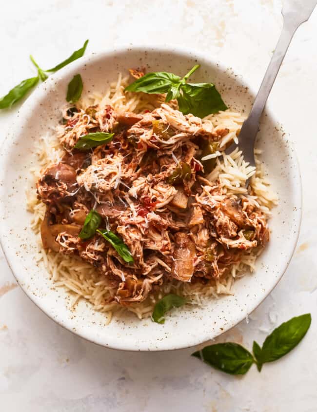 A white bowl with rice and meat in it.