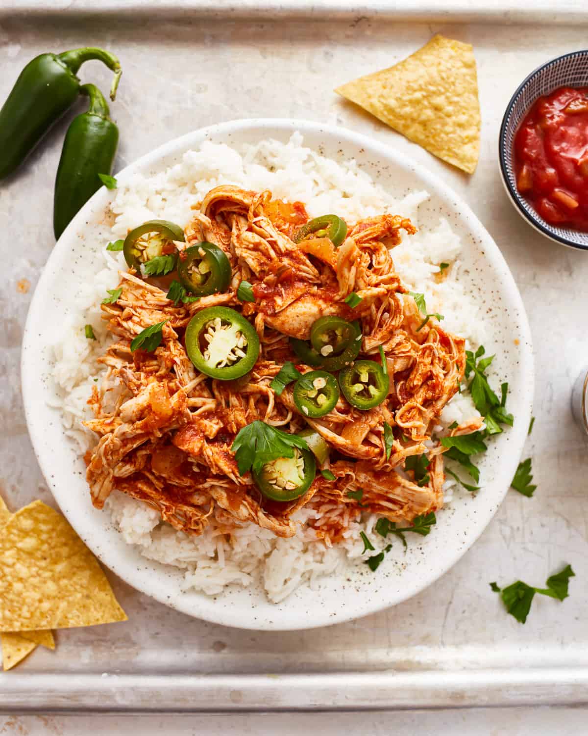 A bowl of rice with chicken and jalapenos.