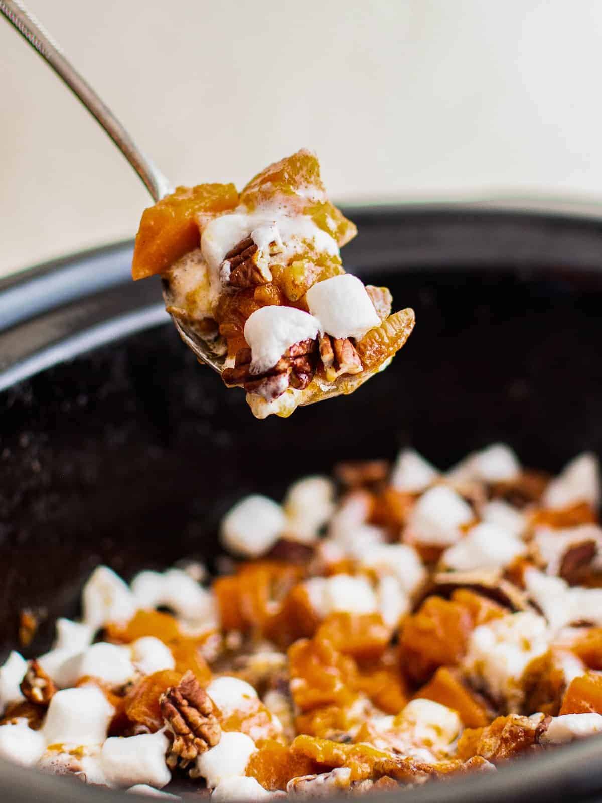 lifting up forkful of sweet potato casserole from crockpot