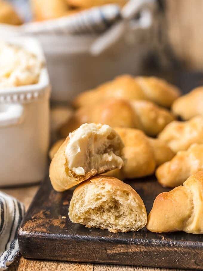 Homemade crescent rolls with butter on a cutting board.