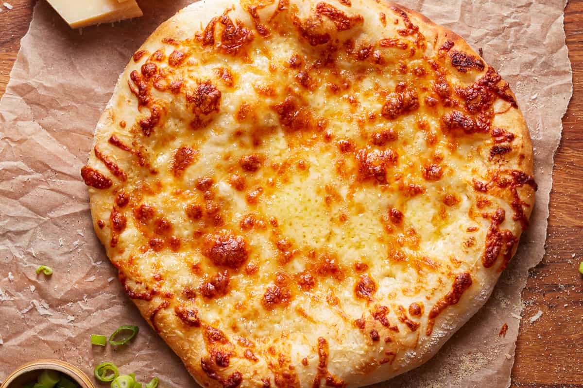 A baked Alfredo pizza, unsliced.